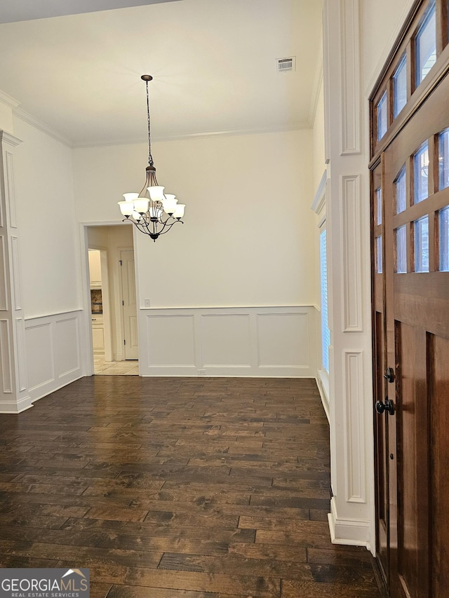 303 Norfolk Cir, Warner Robins, GA 31088 - foyer entrance featuring a decorative wall, ornamental molding, a chandelier, dark wood finished floors, and a wainscoted wall