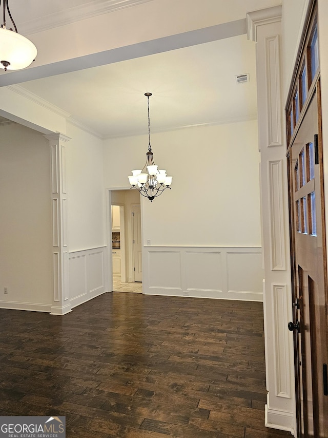 303 Norfolk Cir, Warner Robins, GA 31088 - empty room with a chandelier, dark wood-style floors, a decorative wall, crown molding, and wainscoting