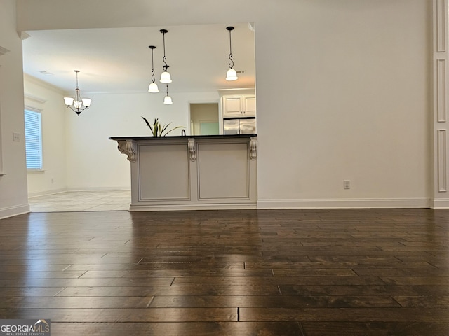 303 Norfolk Cir, Warner Robins, GA 31088 - kitchen with stainless steel refrigerator, dark wood-style floors, a chandelier, pendant lighting, and dark countertops
