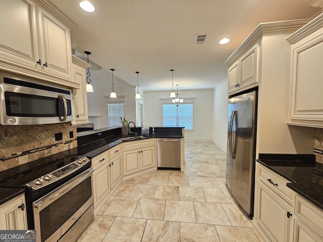 303 Norfolk Cir, Warner Robins, GA 31088 - kitchen with appliances with stainless steel finishes, cream cabinets, decorative backsplash, a peninsula, and recessed lighting