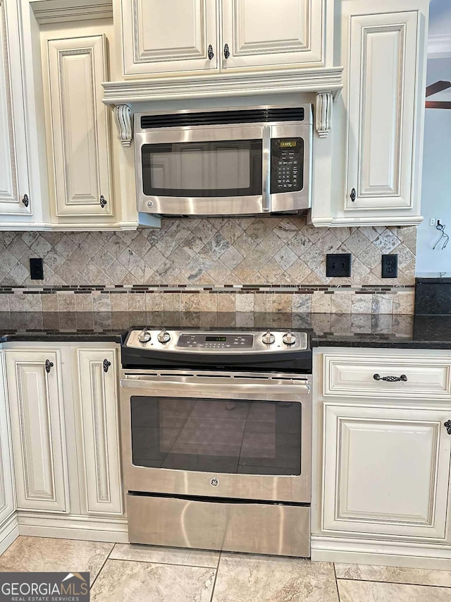 303 Norfolk Cir, Warner Robins, GA 31088 - kitchen featuring appliances with stainless steel finishes, cream cabinetry, dark stone counters, and decorative backsplash