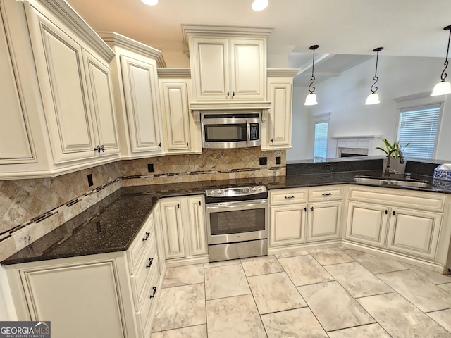 303 Norfolk Cir, Warner Robins, GA 31088 - kitchen with stainless steel appliances, cream cabinetry, a fireplace, and decorative backsplash