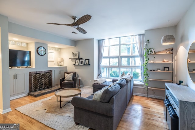 1192 Cleburne Ave NE, Atlanta, GA 30307 - living area featuring ceiling fan, a fireplace with raised hearth, and light wood-style flooring