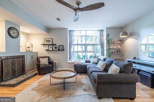 1192 Cleburne Ave NE, Atlanta, GA 30307 - living room featuring light wood-type flooring, ceiling fan, and a fireplace with raised hearth