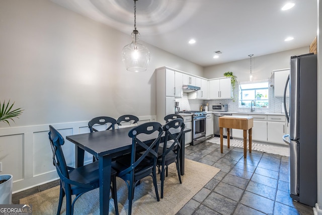 1192 Cleburne Ave NE, Atlanta, GA 30307 - dining space featuring stone tile floors, a wainscoted wall, a decorative wall, and recessed lighting