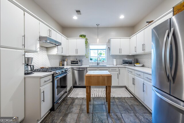 1192 Cleburne Ave NE, Atlanta, GA 30307 - kitchen featuring stainless steel appliances, under cabinet range hood, light countertops, decorative backsplash, and recessed lighting