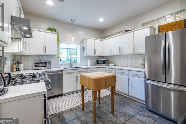 1192 Cleburne Ave NE, Atlanta, GA 30307 - kitchen featuring stainless steel appliances, exhaust hood, light countertops, tasteful backsplash, and white cabinets