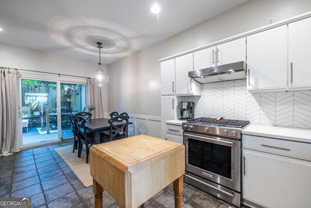 1192 Cleburne Ave NE, Atlanta, GA 30307 - kitchen featuring stainless steel gas stove, under cabinet range hood, decorative backsplash, white cabinetry, and pendant lighting