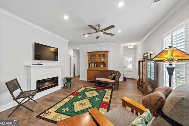 1290 Starboard Way, Greensboro, GA 30642 - living room with ceiling fan, crown molding, healthy amount of natural light, recessed lighting, and a glass covered fireplace