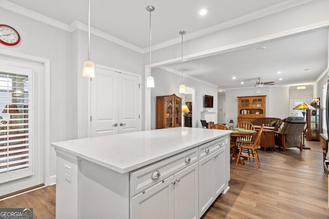 1290 Starboard Way, Greensboro, GA 30642 - kitchen with crown molding, light wood-style flooring, pendant lighting, white cabinets, and recessed lighting
