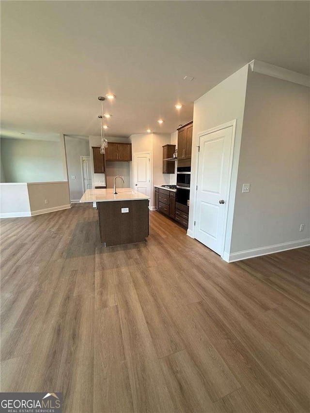 4266 Azalea Ridge Way, Hoschton, GA 30548 - kitchen featuring open floor plan, a center island with sink, dark wood-style flooring, light countertops, and recessed lighting