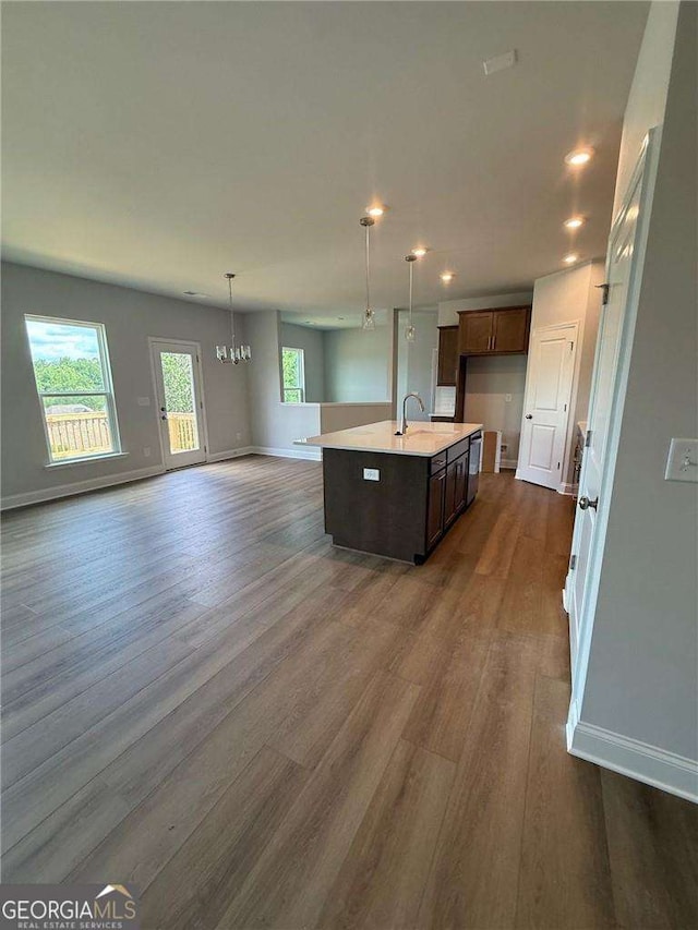 4266 Azalea Ridge Way, Hoschton, GA 30548 - kitchen with dark wood finished floors, light countertops, a center island with sink, open floor plan, and a chandelier