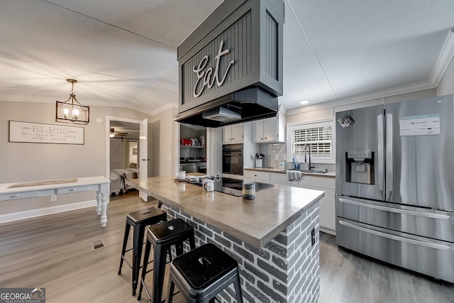 281 Jones Rd, Jefferson, GA 30549 - kitchen featuring stainless steel fridge with ice dispenser, black oven, cooktop, crown molding, and light wood-style flooring
