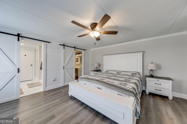 281 Jones Rd, Jefferson, GA 30549 - bedroom featuring a barn door, wood finished floors, crown molding, ceiling fan, and ensuite bath