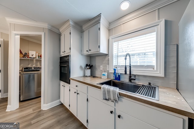 281 Jones Rd, Jefferson, GA 30549 - kitchen featuring washer / dryer, oven, backsplash, butcher block countertops, and light wood-type flooring