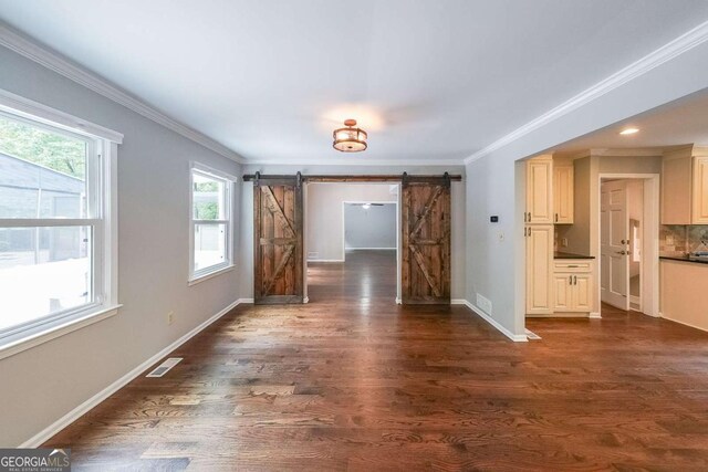 9805 Buice Rd, Alpharetta, GA 30022 - empty room featuring a barn door, ornamental molding, and dark wood finished floors
