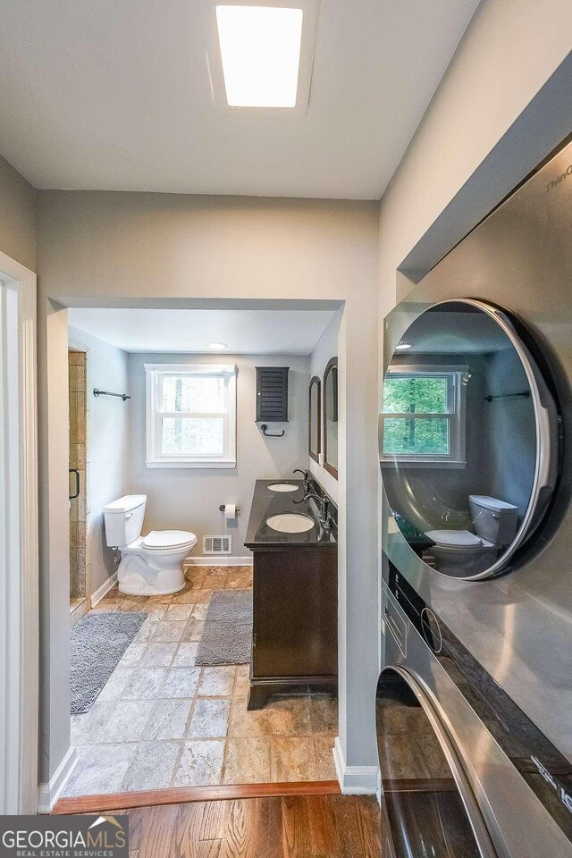 9805 Buice Rd, Alpharetta, GA 30022 - bathroom with vanity, a stall shower, and estacked washer and dryer