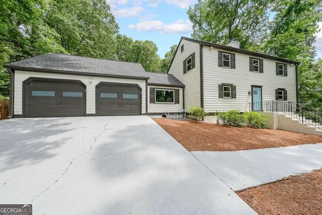 9805 Buice Rd, Alpharetta, GA 30022 - colonial house featuring a chimney, driveway, and a garage