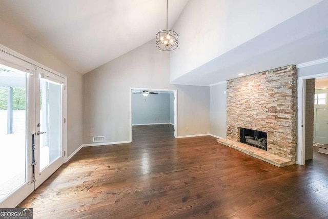 9805 Buice Rd, Alpharetta, GA 30022 - unfurnished living room with high vaulted ceiling, a chandelier, wood finished floors, a fireplace, and a ceiling fan