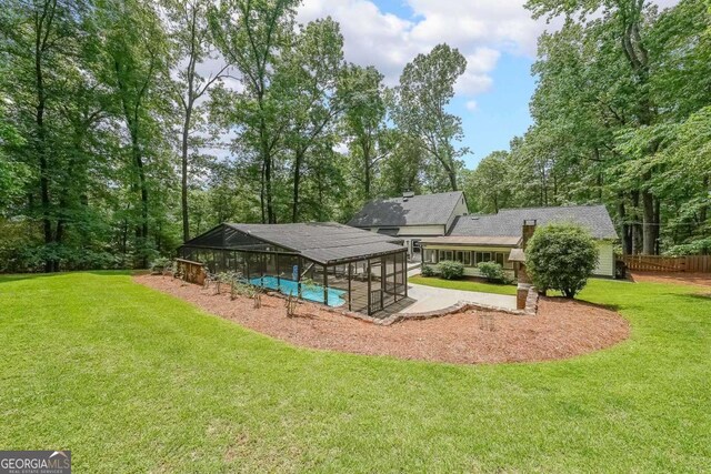9805 Buice Rd, Alpharetta, GA 30022 - rear view of house featuring an outdoor pool, a lawn, a patio, and glass enclosure