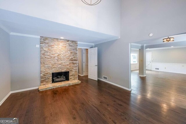 9805 Buice Rd, Alpharetta, GA 30022 - unfurnished living room featuring crown molding, wood finished floors, a fireplace, and a towering ceiling