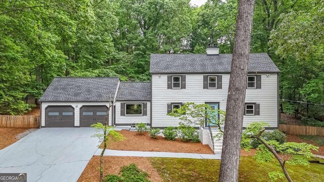 9805 Buice Rd, Alpharetta, GA 30022 - colonial inspired home featuring an attached garage, a shingled roof, driveway, and a chimney