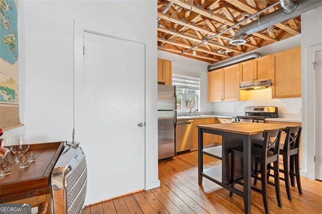 322 Peters Unit 2, Atlanta, GA 30313 - kitchen featuring stainless steel appliances, light wood finished floors, under cabinet range hood, light brown cabinetry, and heating unit