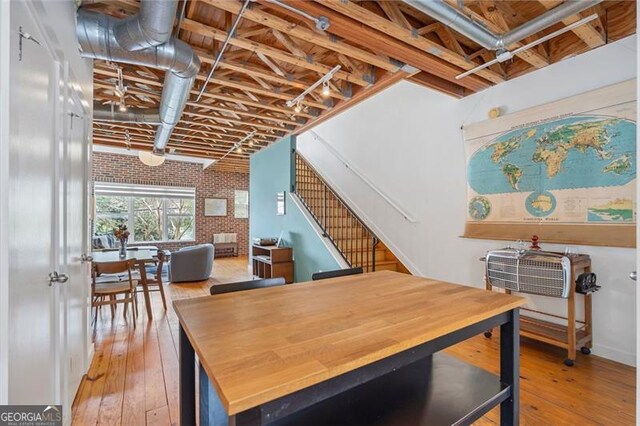 322 Peters Unit 2, Atlanta, GA 30313 - dining space featuring brick wall, hardwood / wood-style floors, a brick fireplace, stairs, and an accent wall