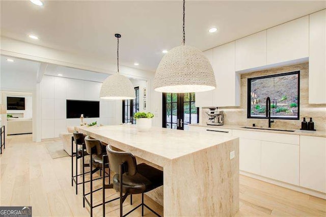 6090 River Chase Cir, Atlanta, GA 30328 - kitchen featuring light wood finished floors, a kitchen island, white cabinetry, light countertops, and recessed lighting
