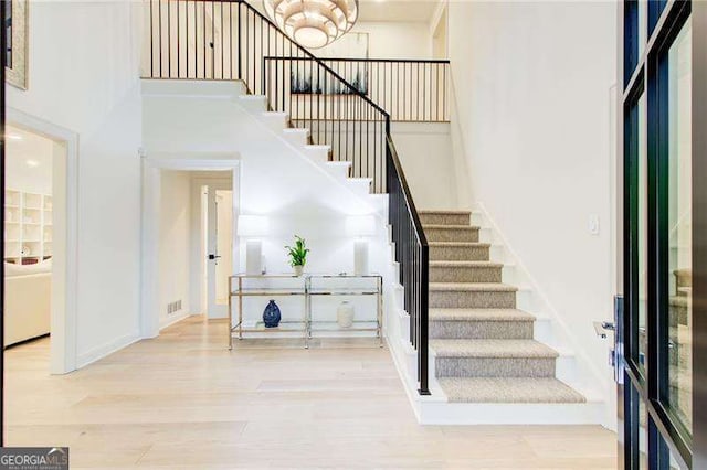 6090 River Chase Cir, Atlanta, GA 30328 - entrance foyer featuring stairway, wood finished floors, a high ceiling, and a chandelier