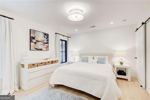 6090 River Chase Cir, Atlanta, GA 30328 - bedroom featuring a barn door and light wood finished floors