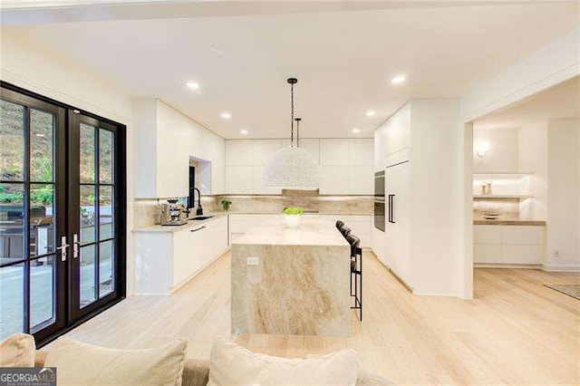 6090 River Chase Cir, Atlanta, GA 30328 - kitchen with modern cabinets, white cabinets, decorative backsplash, light countertops, and a center island