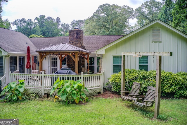 2440 Weatherford Ct, Marietta, GA 30068 - view of front of house featuring a gazebo, board and batten siding, a front lawn, a chimney, and a wooden deck