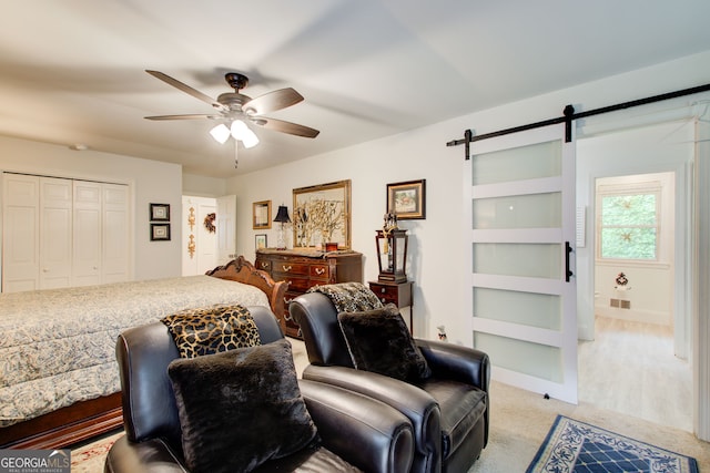 2440 Weatherford Ct, Marietta, GA 30068 - bedroom with light colored carpet, a barn door, a ceiling fan, and a closet
