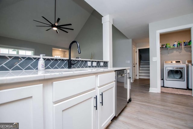 328 Brookstone Dr, Carrollton, GA 30116 - kitchen with stainless steel dishwasher, washer and clothes dryer, white cabinets, light wood finished floors, and a ceiling fan
