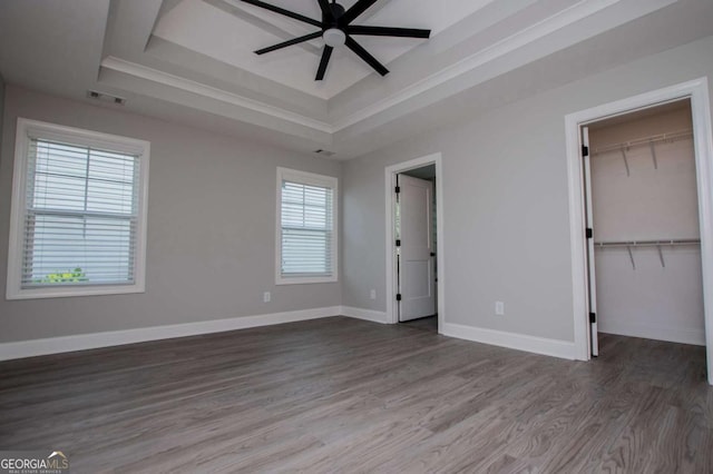 328 Brookstone Dr, Carrollton, GA 30116 - unfurnished bedroom with a raised ceiling, a walk in closet, wood finished floors, a closet, and a ceiling fan