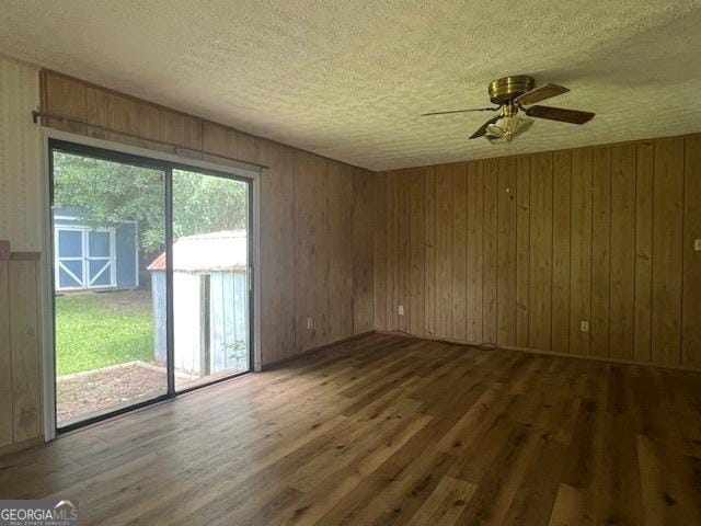 1041 Sandy Ridge Rd, Mcdonough, GA 30252 - empty room featuring wood finished floors, a textured ceiling, ceiling fan, and wood walls