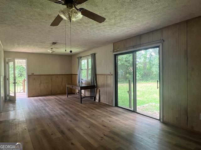 1041 Sandy Ridge Rd, Mcdonough, GA 30252 - unfurnished room with wood-type flooring, a ceiling fan, wood walls, and a textured ceiling