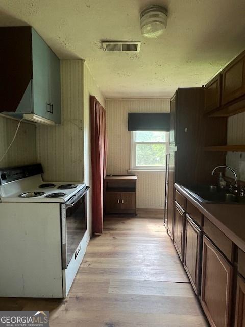 1041 Sandy Ridge Rd, Mcdonough, GA 30252 - kitchen featuring white range with electric stovetop, light wood finished floors, open shelves, and dark countertops