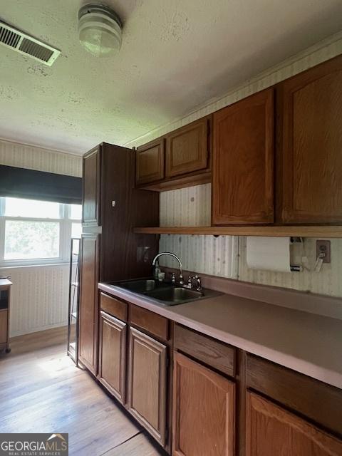 1041 Sandy Ridge Rd, Mcdonough, GA 30252 - kitchen featuring light wood finished floors, open shelves, light countertops, and a textured ceiling