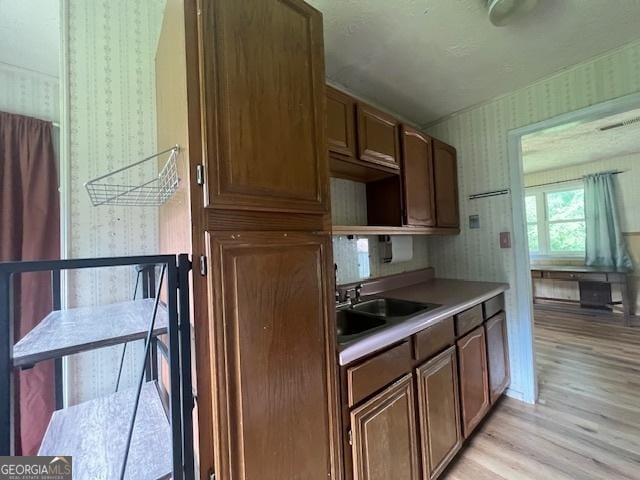 1041 Sandy Ridge Rd, Mcdonough, GA 30252 - kitchen with wallpapered walls, light wood-style flooring, and light countertops