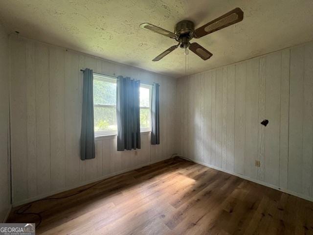 1041 Sandy Ridge Rd, Mcdonough, GA 30252 - spare room with wood finished floors, ceiling fan, and wood walls
