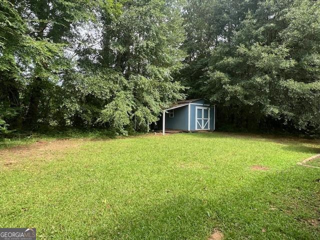 1041 Sandy Ridge Rd, Mcdonough, GA 30252 - view of green lawn with a shed