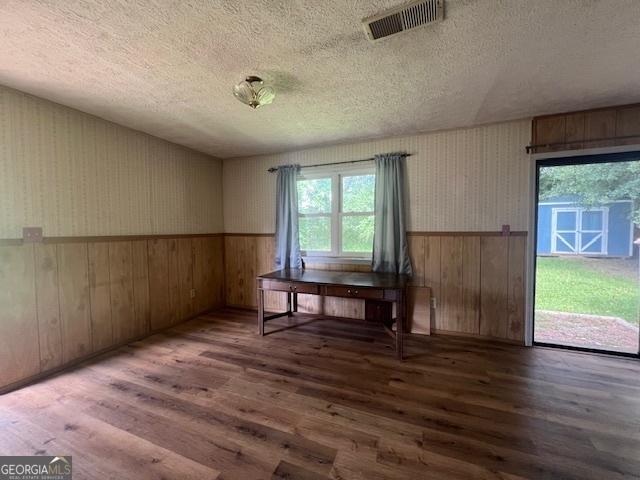 1041 Sandy Ridge Rd, Mcdonough, GA 30252 - unfurnished dining area featuring a textured ceiling, wood finished floors, wainscoting, plenty of natural light, and wooden walls