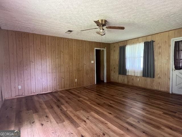 1041 Sandy Ridge Rd, Mcdonough, GA 30252 - spare room featuring wood finished floors, a ceiling fan, a textured ceiling, and wood walls
