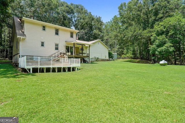 292 Selfridge Rd, Mcdonough, GA 30252 - back of property featuring a deck, a lawn, a shingled roof, and view of wooded area