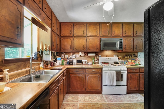 292 Selfridge Rd, Mcdonough, GA 30252 - kitchen with black appliances, a ceiling fan, light countertops, stone finish flooring, and brown cabinetry