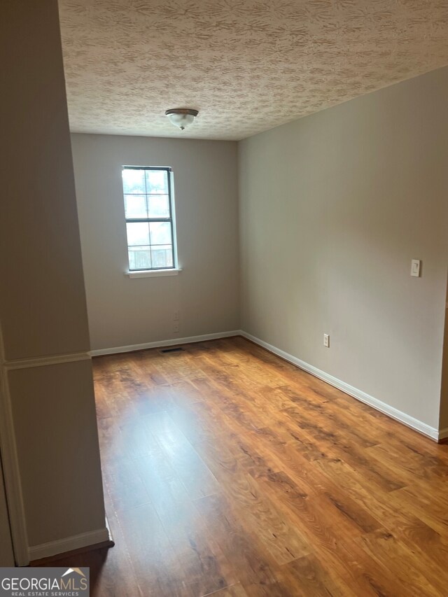 470 Huntington Rd Unit 5, Athens, GA 30606 - empty room featuring wood finished floors and a textured ceiling