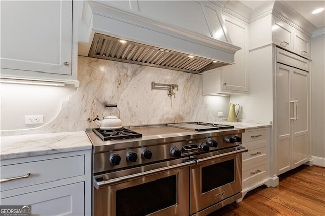 510 Heards Ferry Rd, Atlanta, GA 30328 - kitchen with double oven range, custom exhaust hood, white cabinetry, and wood finished floors