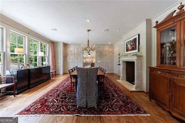 510 Heards Ferry Rd, Atlanta, GA 30328 - dining space with a decorative wall, crown molding, a chandelier, light wood-style floors, and a fireplace